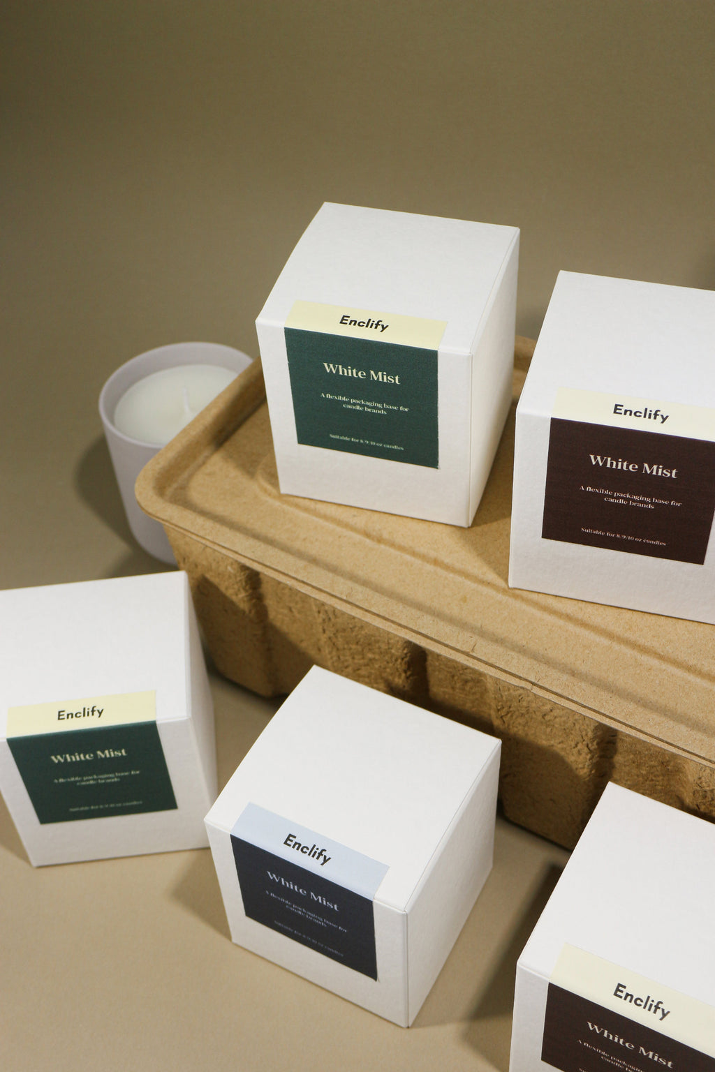 White square candle boxes with colorful 'Enclify White Mist' labels on a brown tray.