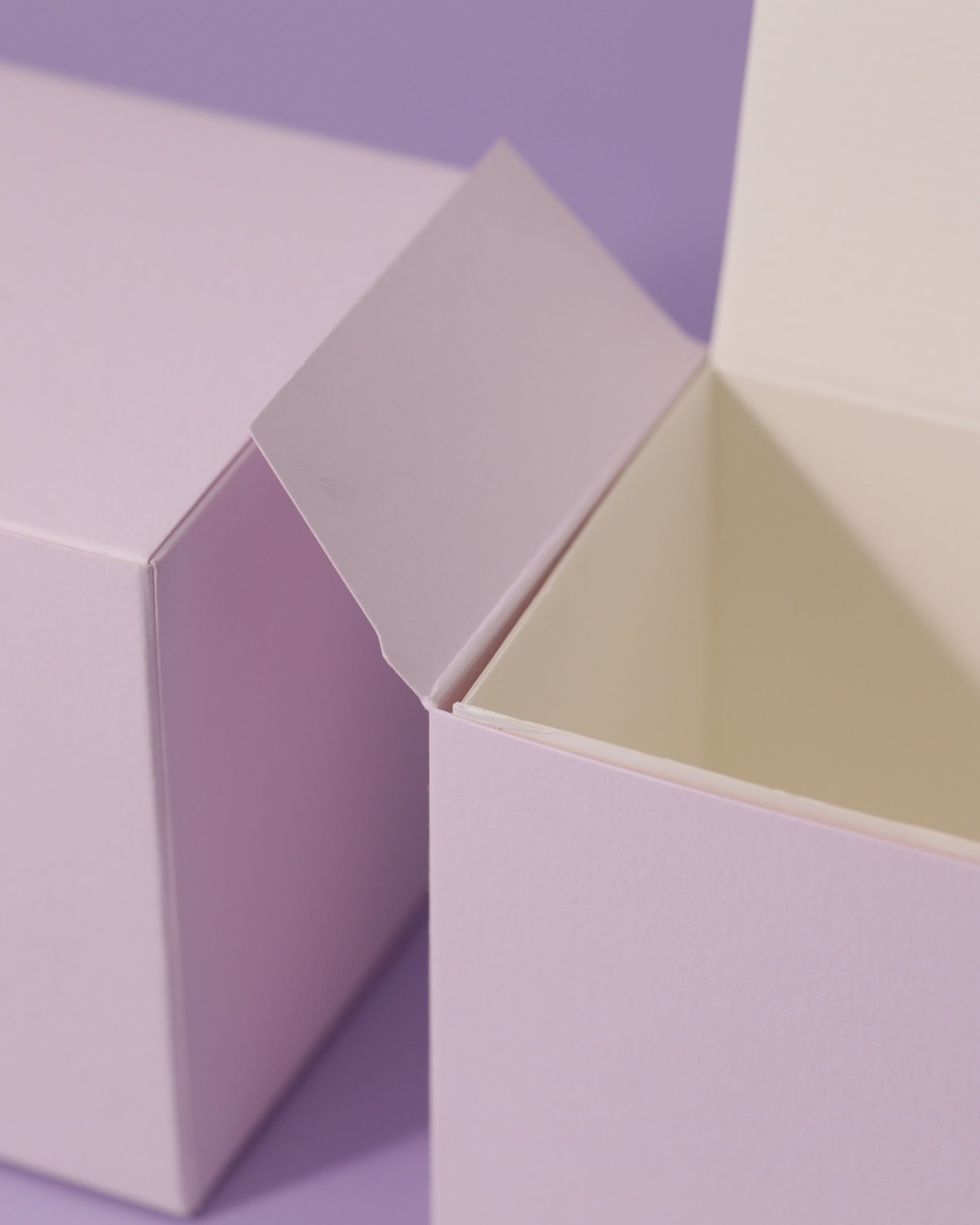 Two light purple boxes, one open revealing a cream interior.